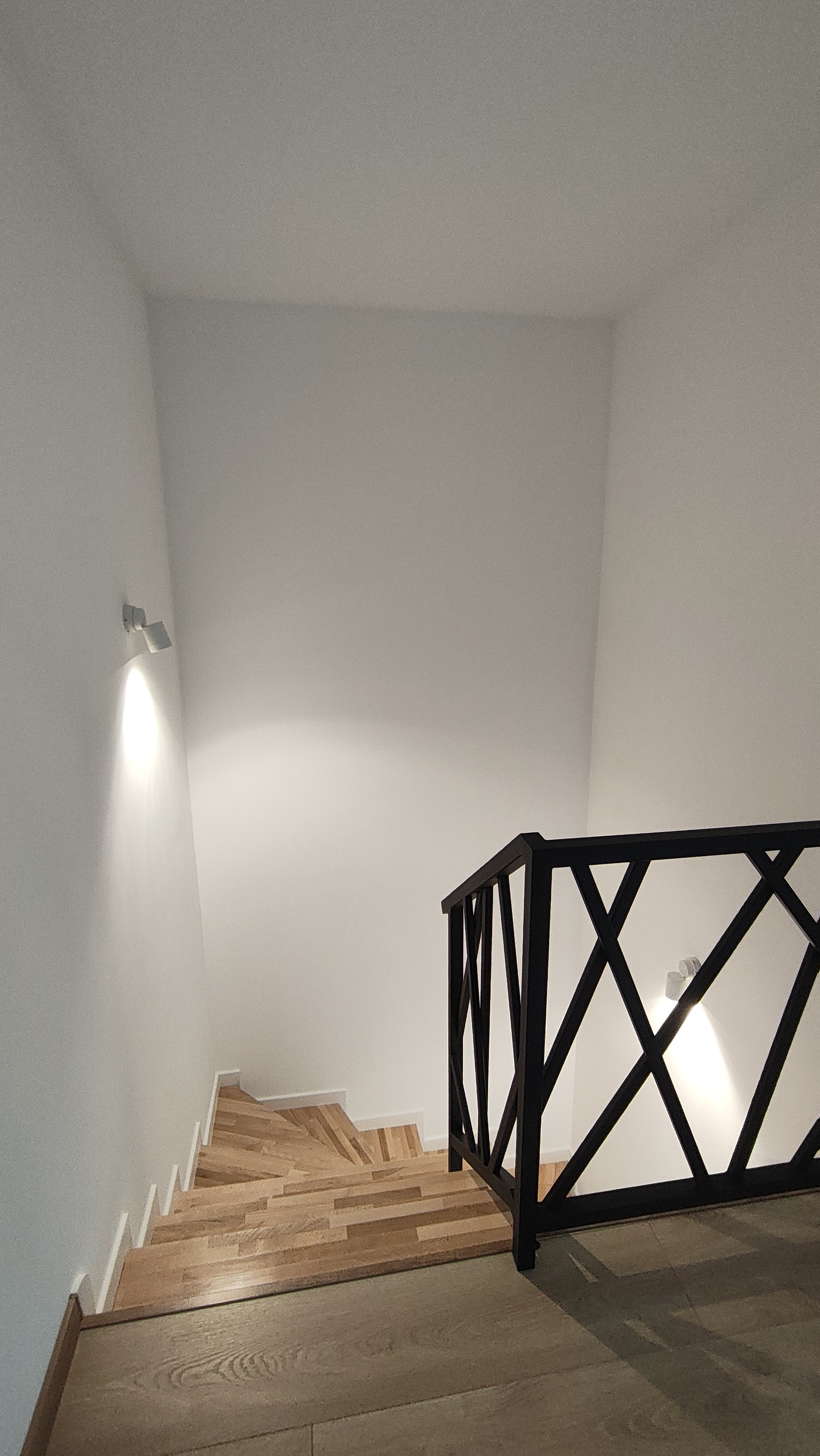 Drewniane schody z czarną stalową balustradą